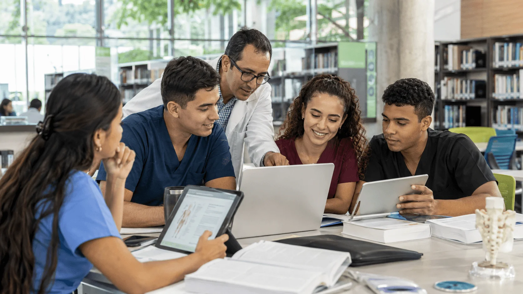 Estudiantes y docente consultando recursos de biblioteca digital para formación e investigación en la ECR.